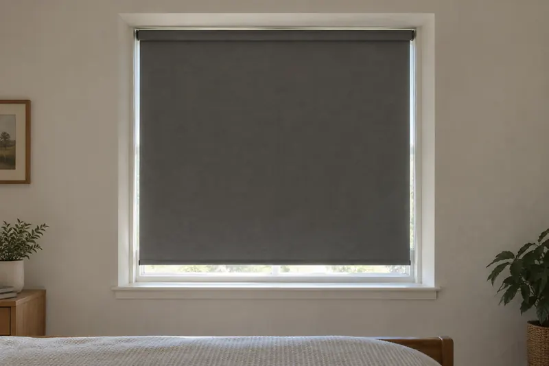 Generic bedroom window with a dark-gray roller shade and visible daylight gaps along its sides and bottom.